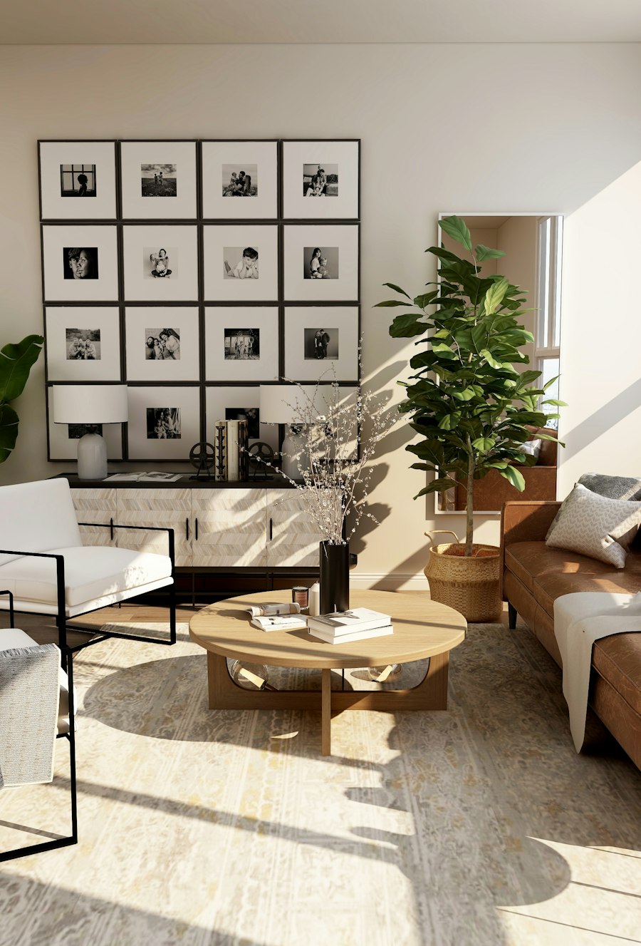 Sunlit living room with a cognac leather sofa, a gallery wall of black and white photographs and tall plants