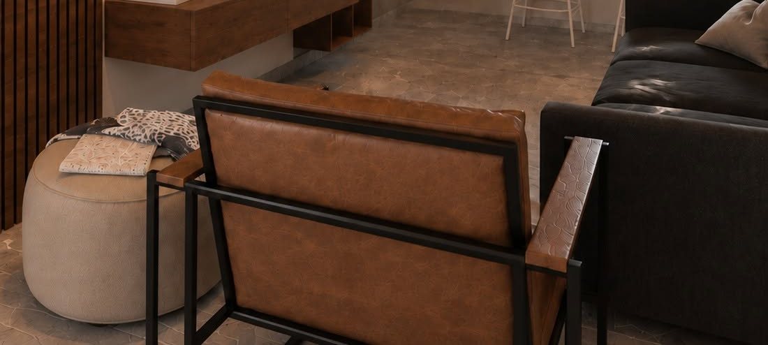 Cognac leather armchair beside a charcoal sofa in a warm living room